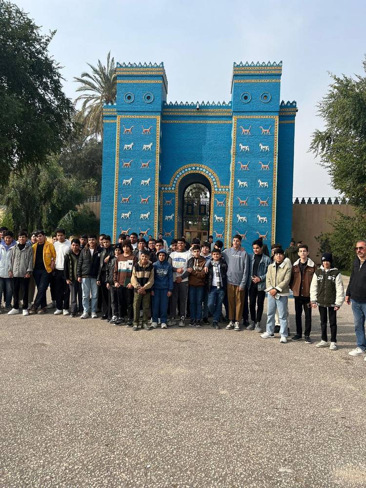 A large group of boys in front of the reconstructed Ishtar Gate at Babylon